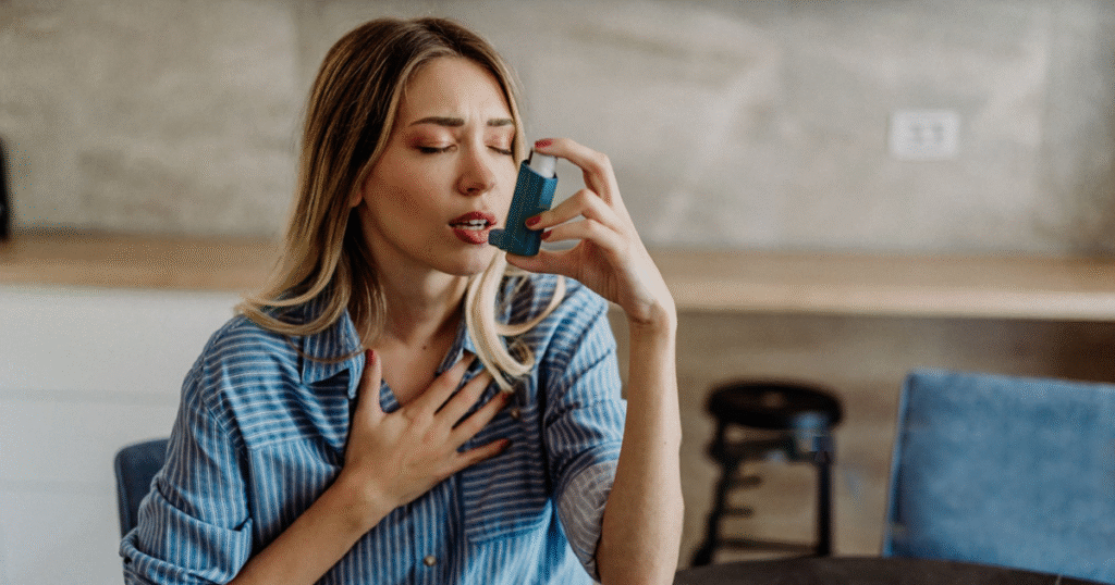 A woman using an asthma attack inhaler to manage her breathing during an asthma episode.