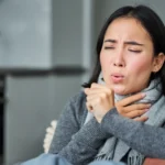 Woman showing symptoms of upper respiratory infection coughing