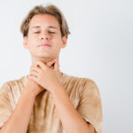 A man in Texas with his hands on his neck, appearing contemplative or in distress.