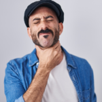 Man holding his throat in pain from a sore throat.